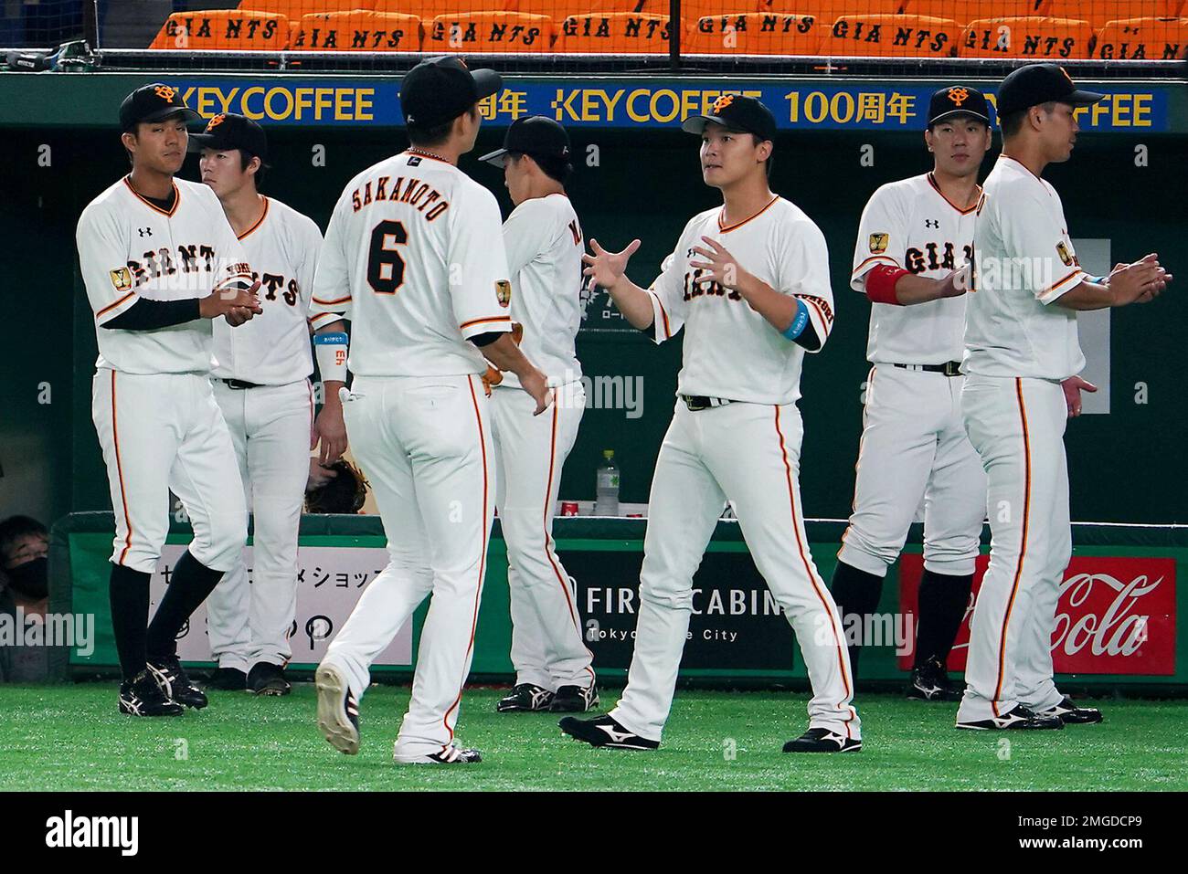 Yomiuri Giants players gather between play in an opening baseball game against the Hanshin Tigers at Tokyo Dome in Tokyo Friday, June 19, 2020