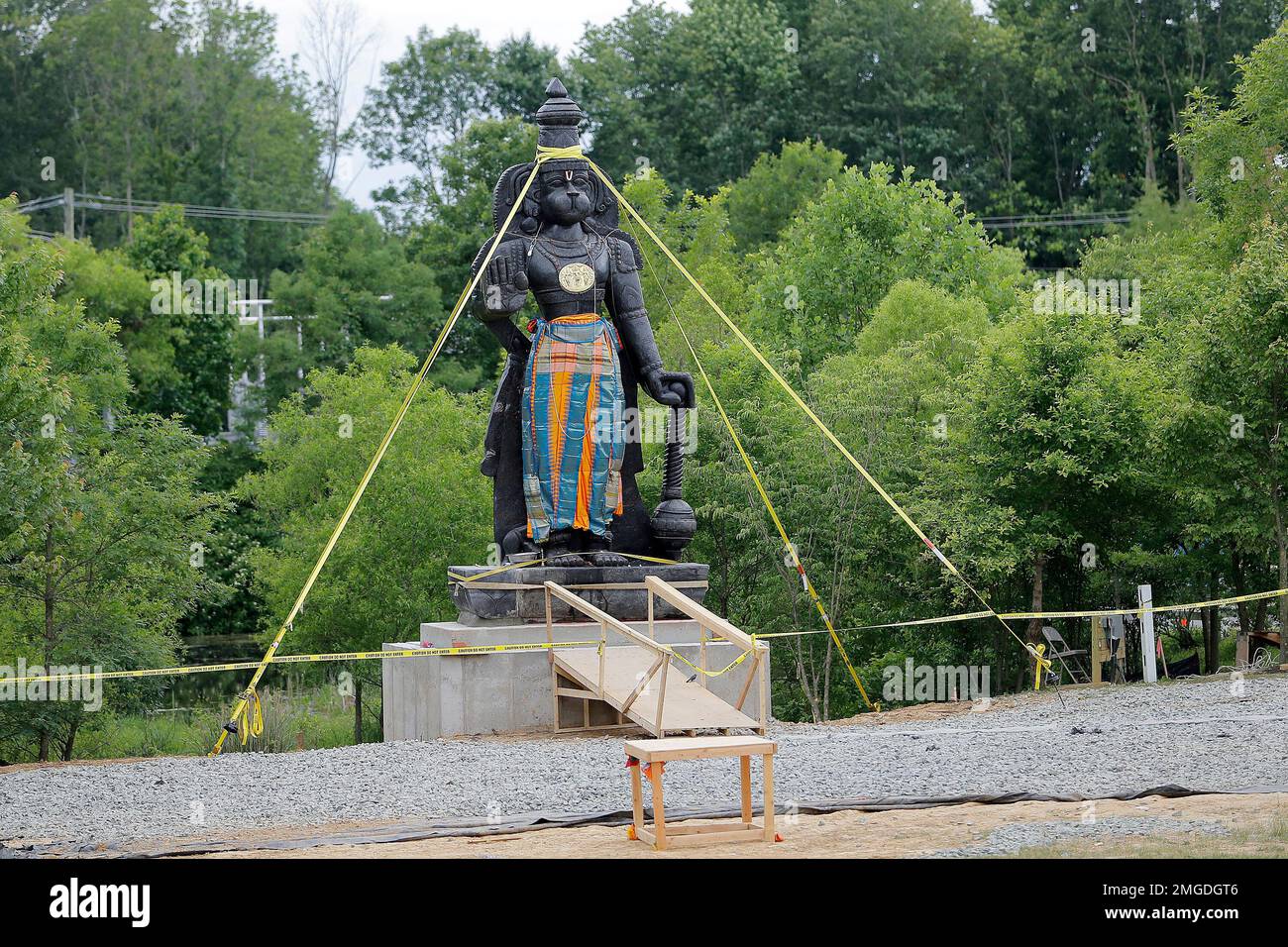 A statue of the Hindu god Hanuman is seen with support straps on the grounds of the Hindu Temple