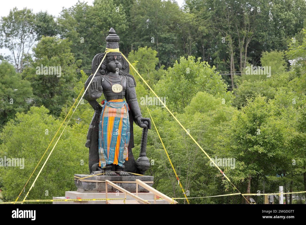 A statue of the Hindu god Hanuman is seen with support straps on the