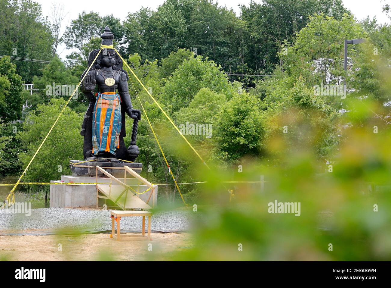 A statue of the Hindu god Hanuman is seen with support straps on the grounds of the Hindu Temple