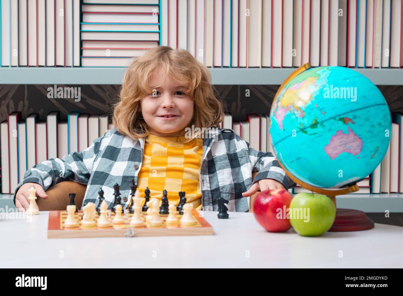 Chess school. Clever concentrated and thinking kid playing chess. Kids brain development and logic game. Stock Photo