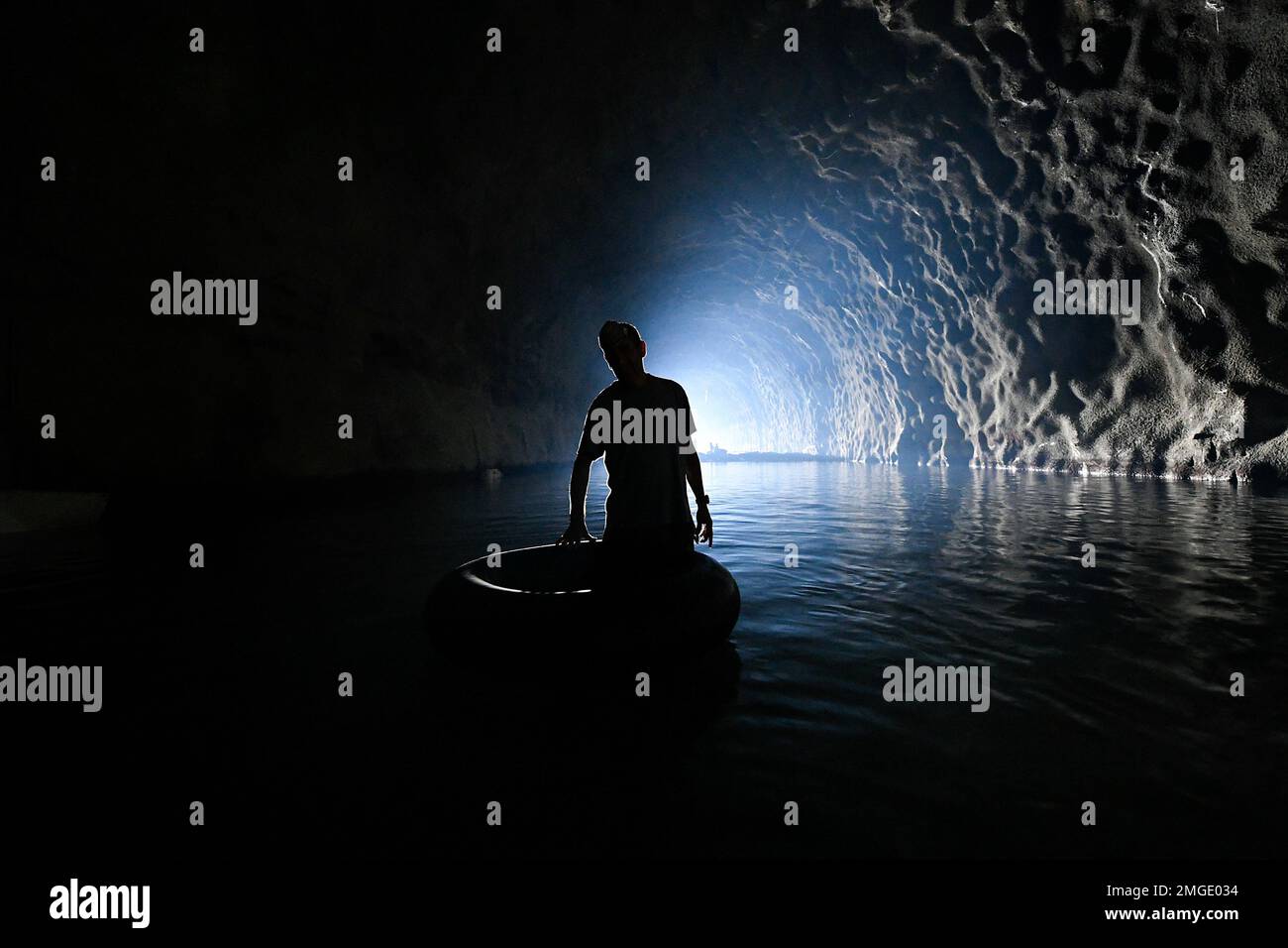 A man waits for his friends who work floating on inner tubes and use