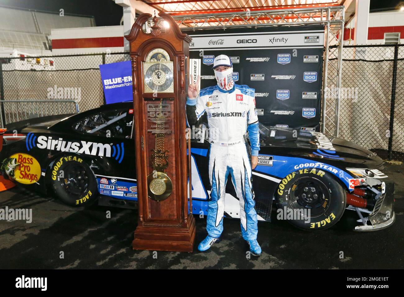 Martin Truex Jr. celebrates with his grandfather clock trophy after