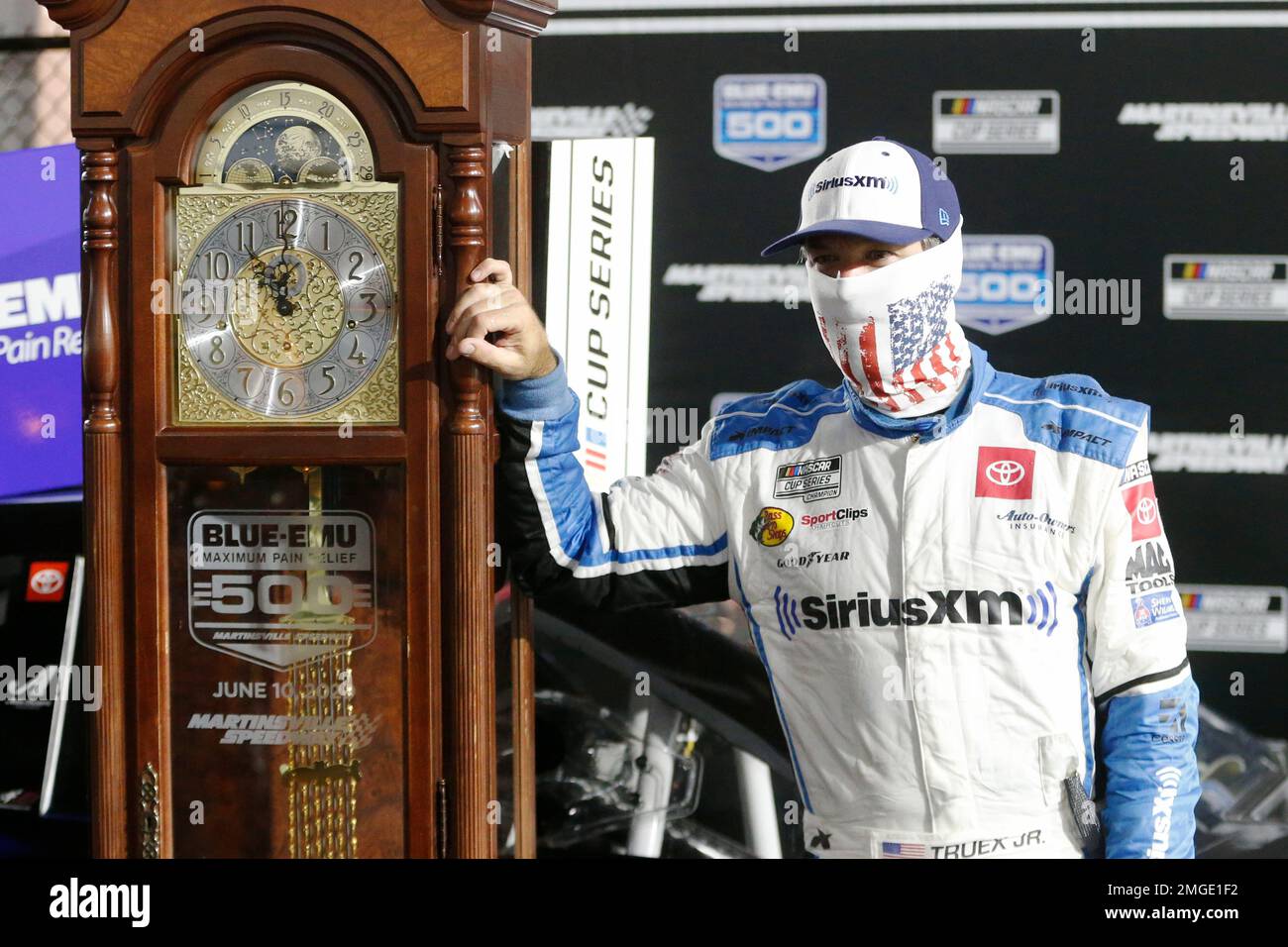 Martin Truex Jr. poses with his grandfather clock trophy after winning