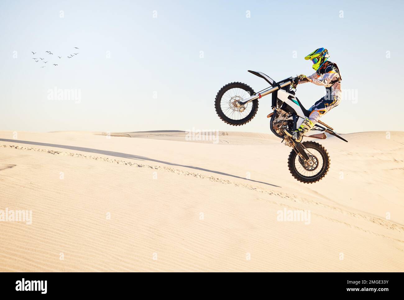 Motorcycle, desert race and air jump for extreme sport expert with agile speed, power or balance in nature. Motorbike man, rally and blue sky on fast Stock Photo