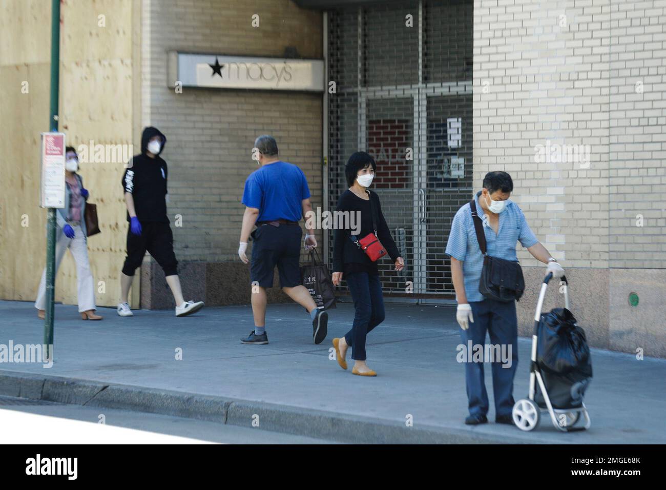 Patrons pass a closed Macy's location on Roosevelt Avenue Monday, June