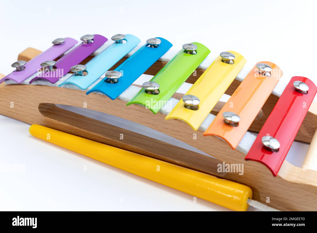 Rainbow colored wooden toy xylophone against white background. Kids toys, creativity, brain development, innovative concept. Stock Photo