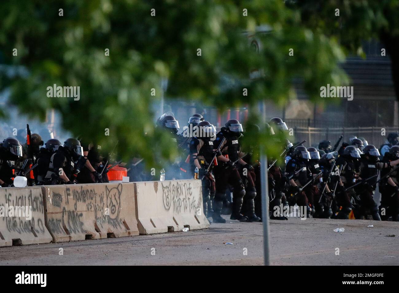 Police in riot gear advance on protesters, Saturday, May 30, 2020, in ...