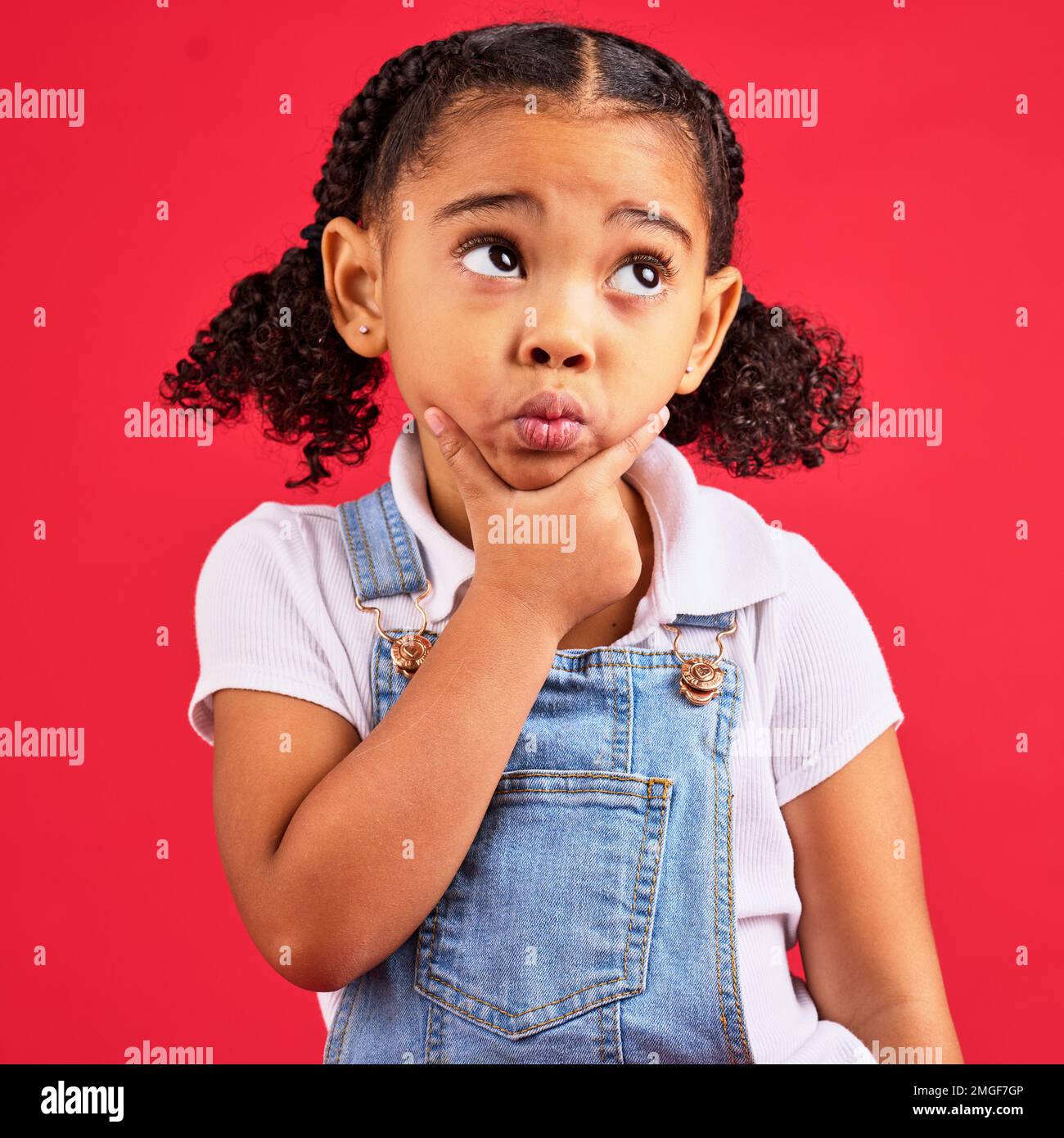 Kid, ideas or thinking face by isolated red background in games innovation, question or planning vision. Little girl, expression or curious finger on Stock Photo
