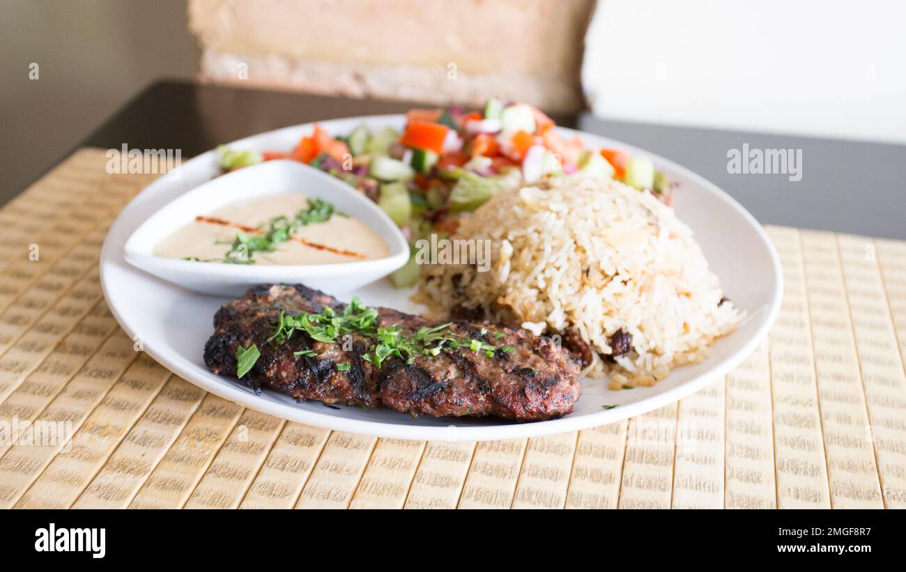 Israeli dish with lamb kebab, rice, salad and tahini Stock Photo Alamy