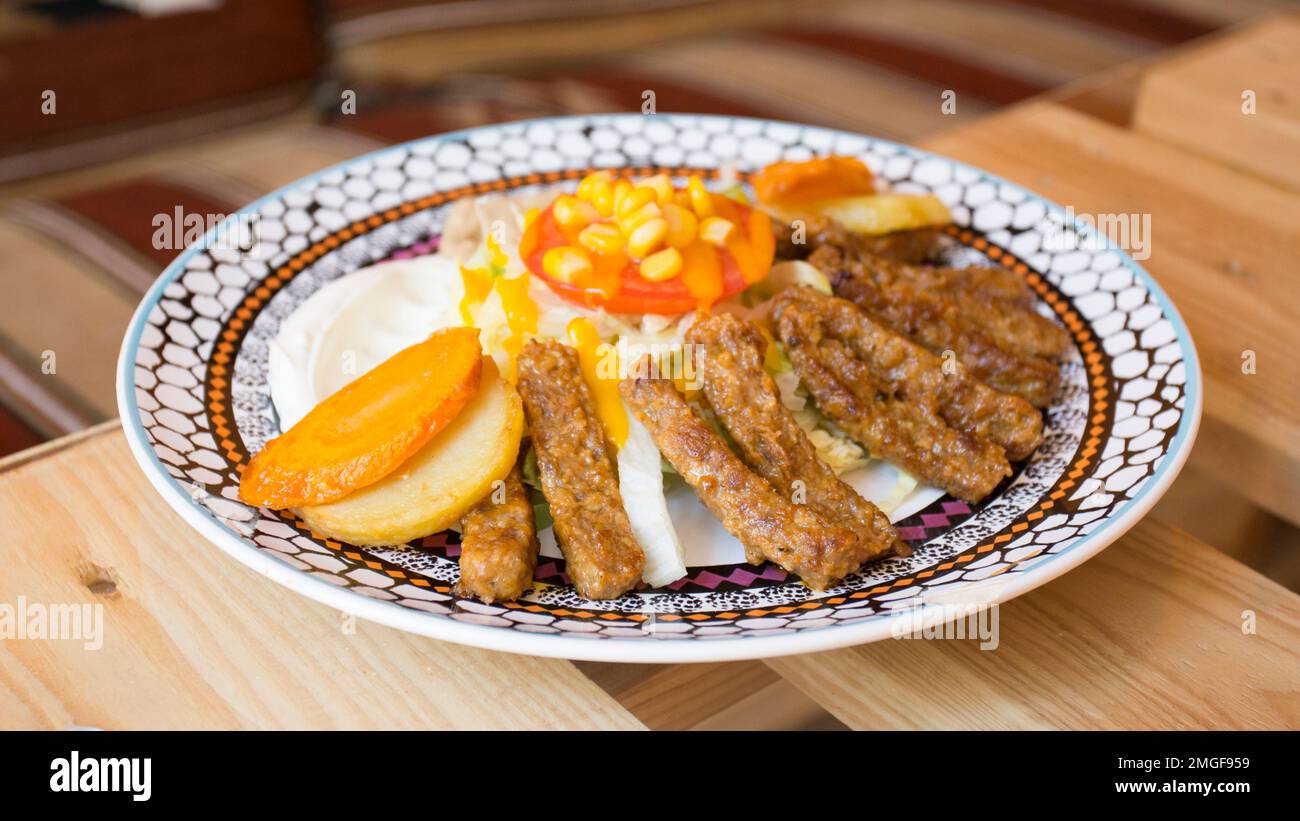 African combo plate with rice, fried cheese, grilled vegetables, peanut sauce and other traditional products. Stock Photo