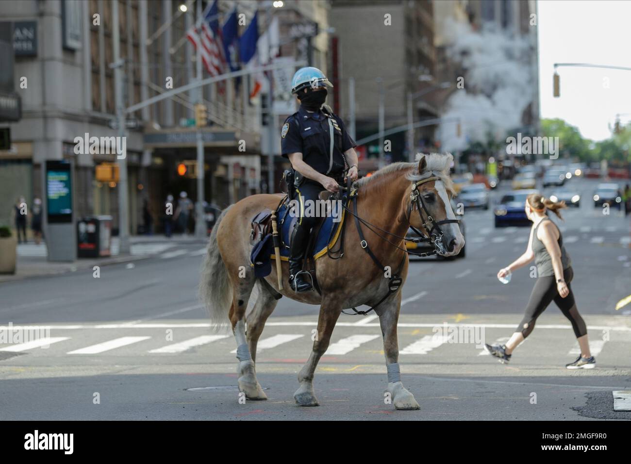 A New York Police Officer wears a protective mask while on patrol near ...
