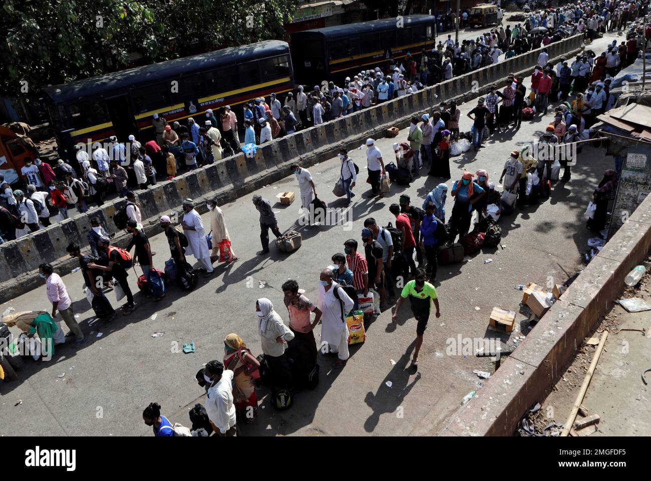 Migrant workers gather for transport to the railway station for their ...