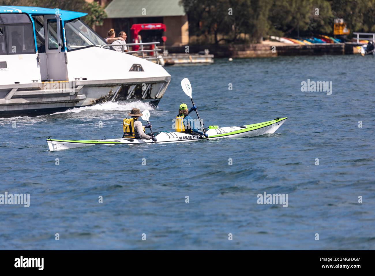 Middle aged couple exercise in the ocean kayak a Mirage 730 on