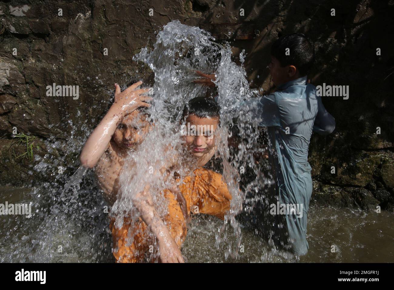 Children take a bath in a canal as the weather turns warm in Peshawar ...
