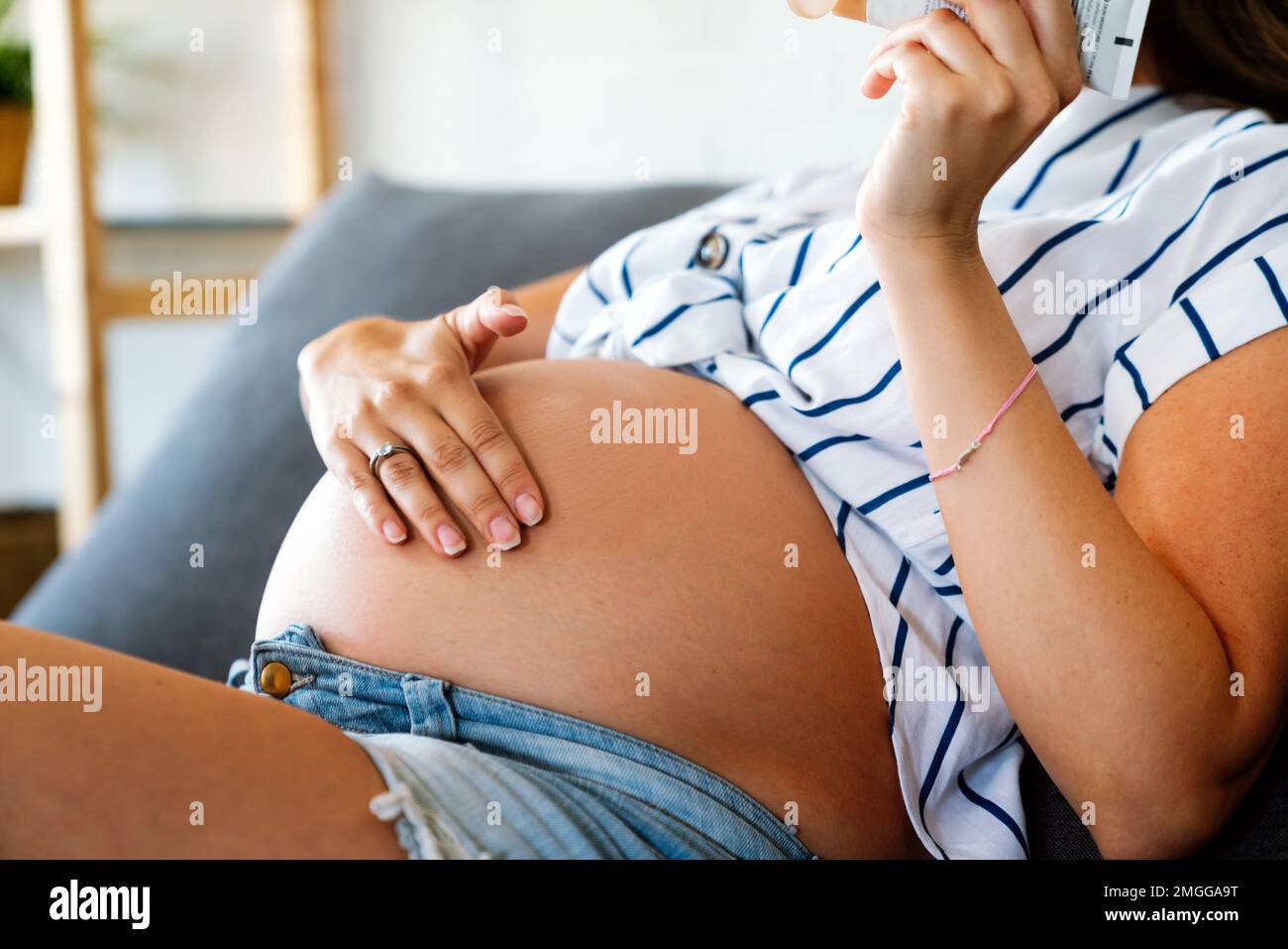 Care about perfect and smooth skin in pregnancy time. Pregnant woman using stretch mark cream