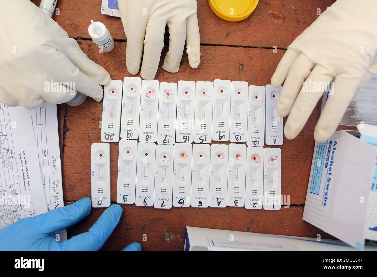 Health workers collect blood samples as they conduct mass testing for