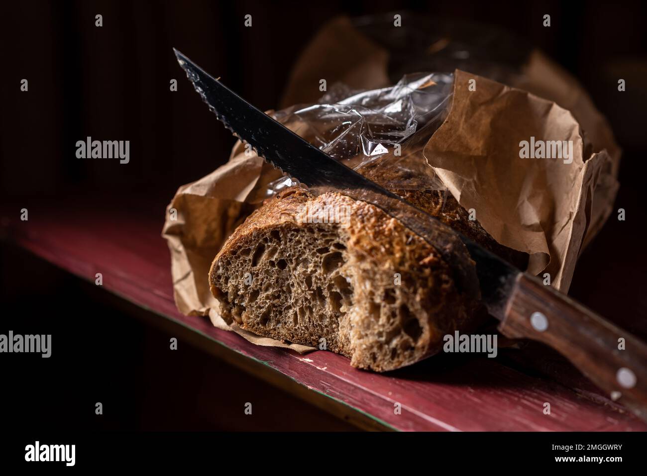 Sliced baguette with a bread knife. Bread made from buckwheat flour. Useful bread. Dark