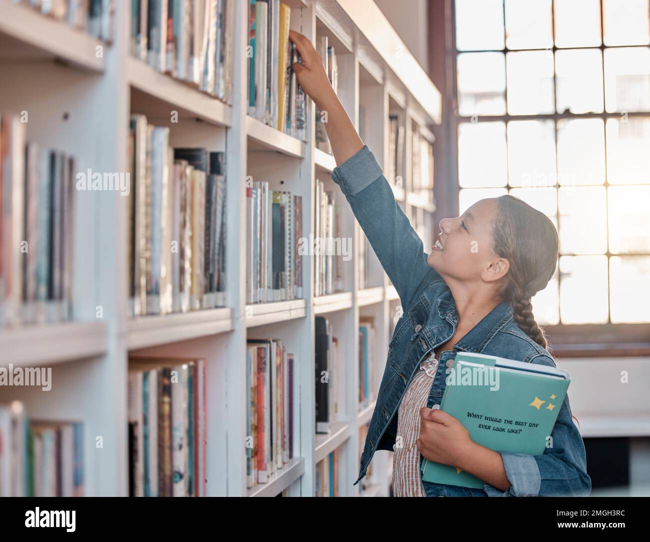 Books, education or child in a library to search for knowledge or development for future learning. Hand reaching, student growth or happy girl Stock Photo