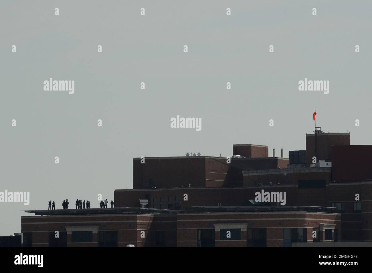 People wait from the rooftop helipad of Children's Mercy Hospital for a