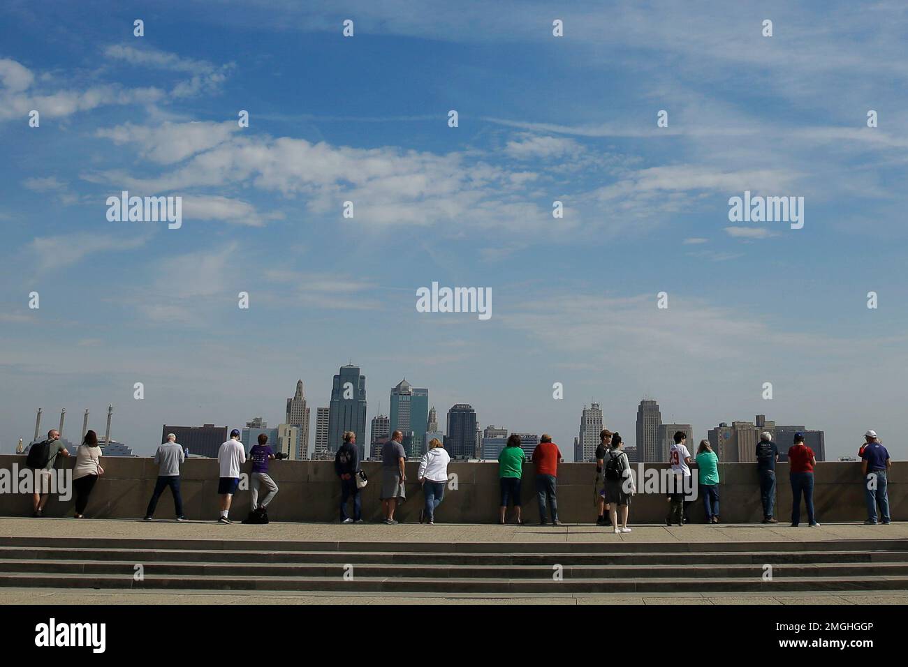 People maintain their distance as they wait for a flyover from nearby