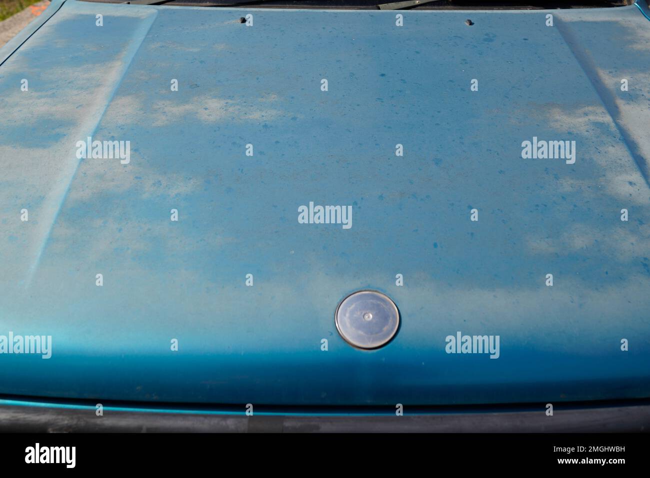 old car engine hood green used paint worn by time season and sun