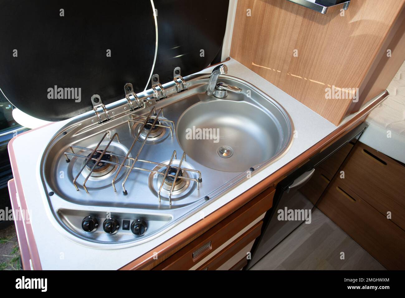 camper van interior with the small kitchen with gas stove fire and sink