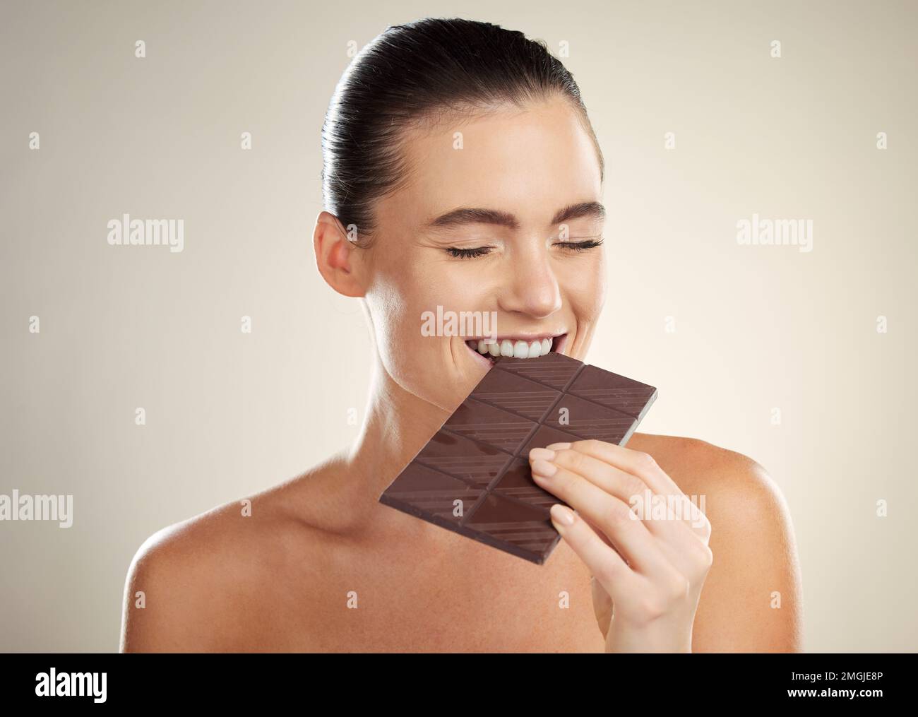 Beauty, eating and face of woman with chocolate bar, junk food or dessert for sugar sweets, candy snack or cheat meal. Cosmetics makeup, skincare and Stock Photo