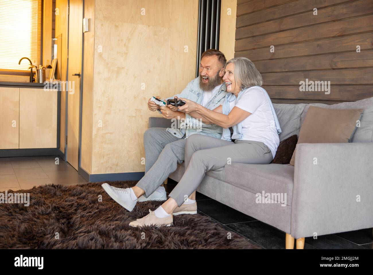 Mature couple playing video games and looking excited Stock Photo