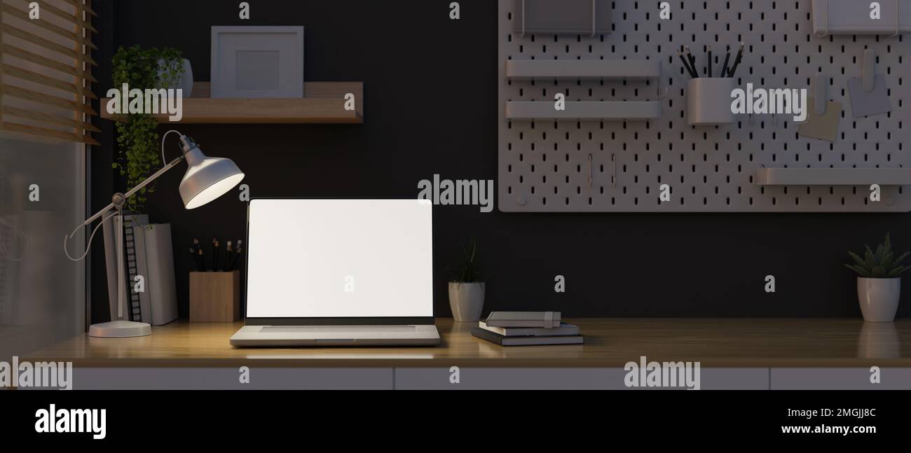 Modern home workstation at night with lights from table lamp, laptop