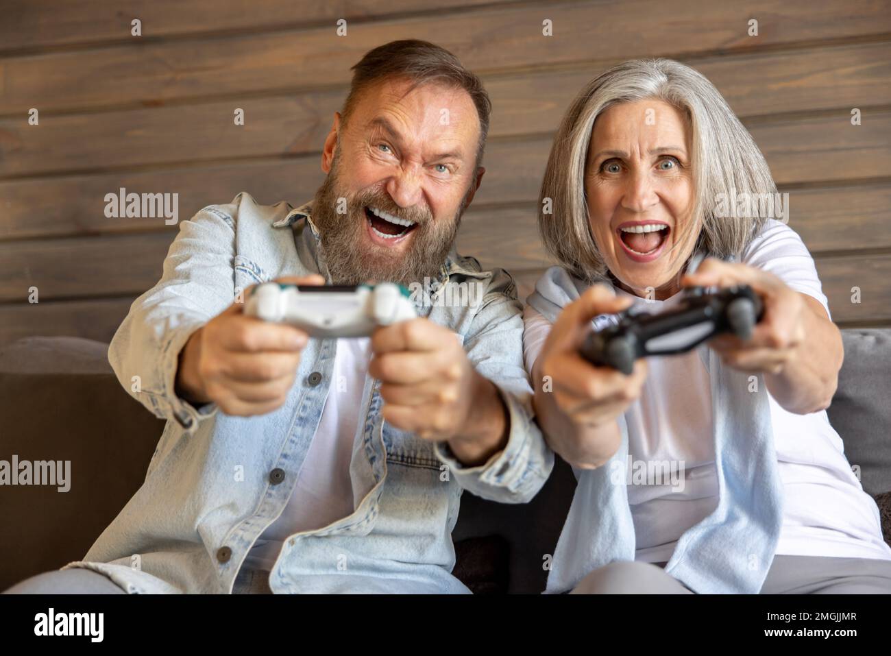 Mature couple playing video games and looking excited Stock Photo