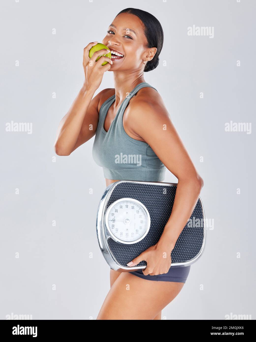 Portrait, scale and black woman eating apple on diet for weightloss
