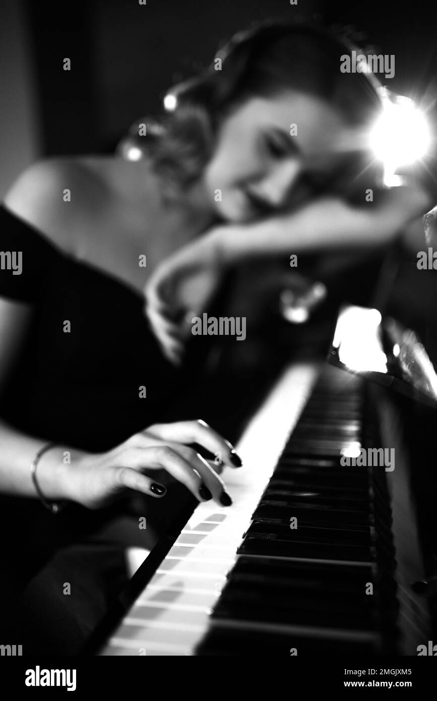 Hand of a girl with colored finger nails playing the piano. soft focus