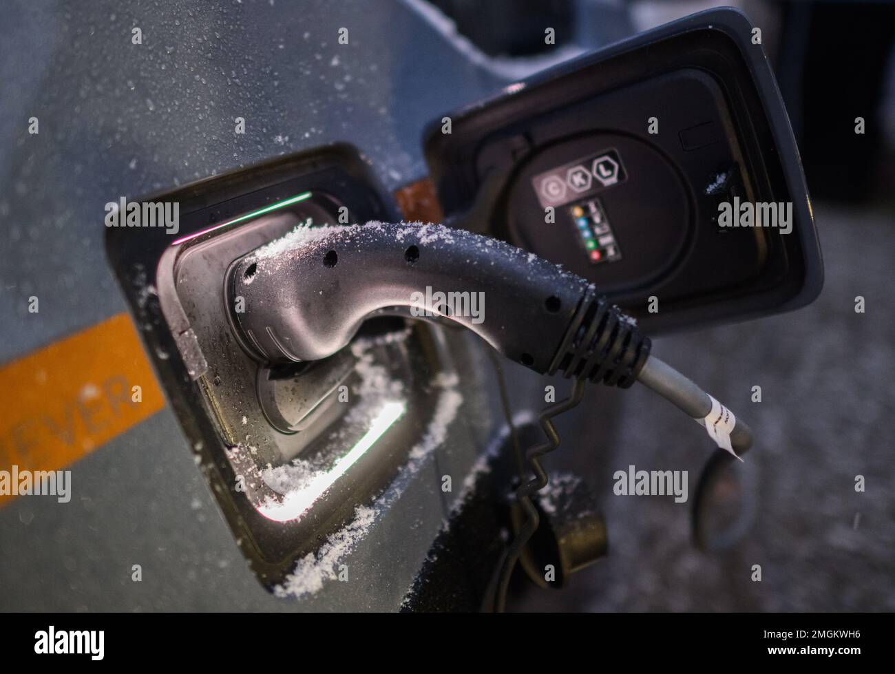 Laatzen, Germany. 26th Jan, 2023. Snowflakes lie on the charging cable of a BWM i3s electric car while charging at a private wallbox at a single-family home in the Hannover region (posed scene). At low temperatures, the range of electric cars decreases significantly. Credit: Julian Stratenschulte/dpa/Alamy Live News Stock Photo