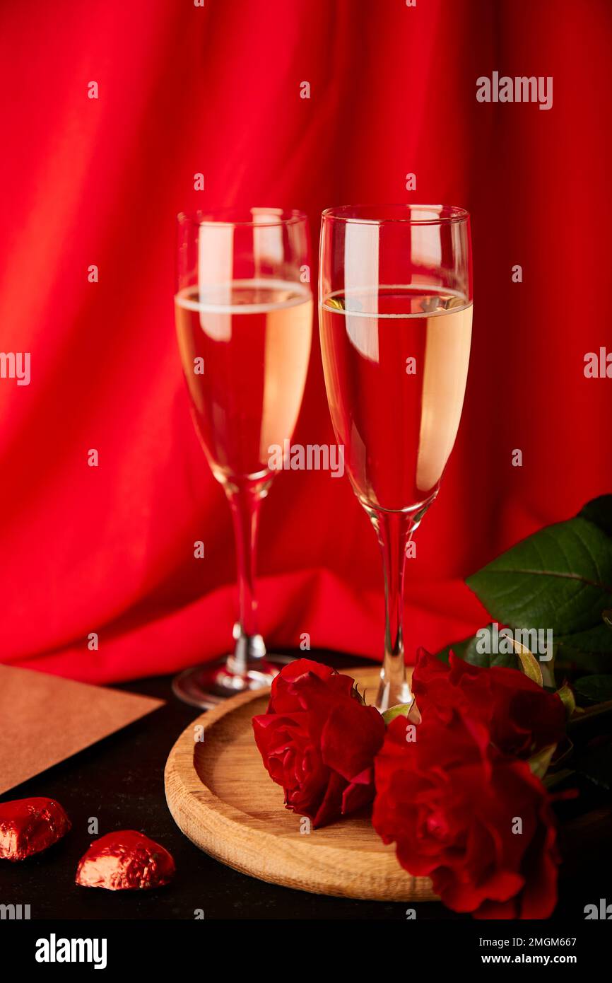 Traditional red romantic St Valentines day background with glasses of champagne, red roses aesthetics. Copy space. Stock Photo