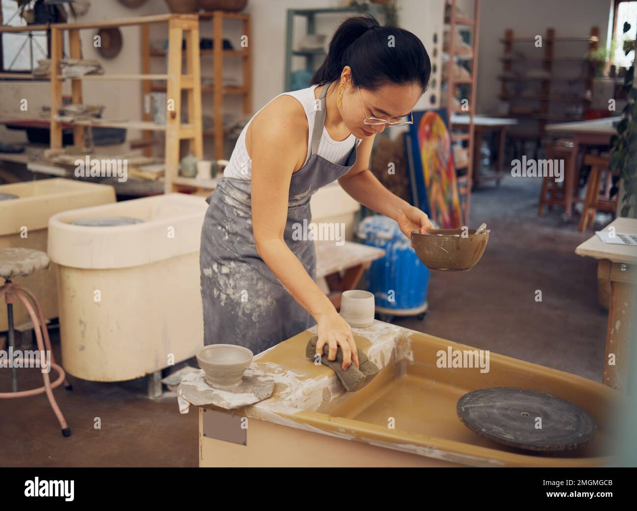 Pottery, startup business and woman cleaning in for art class