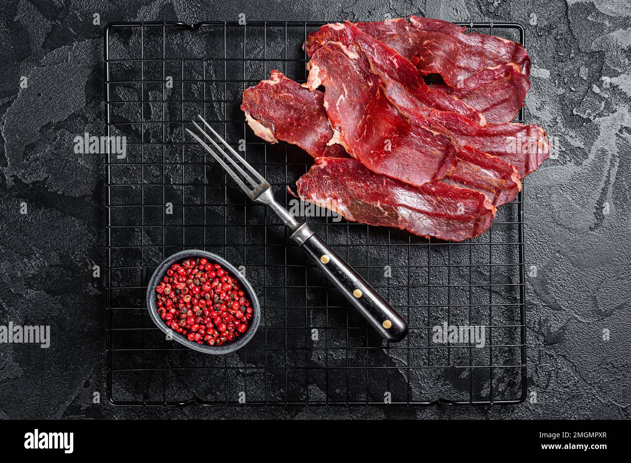 Dried sliced basturma, cured beef meat ready for eat. Black background