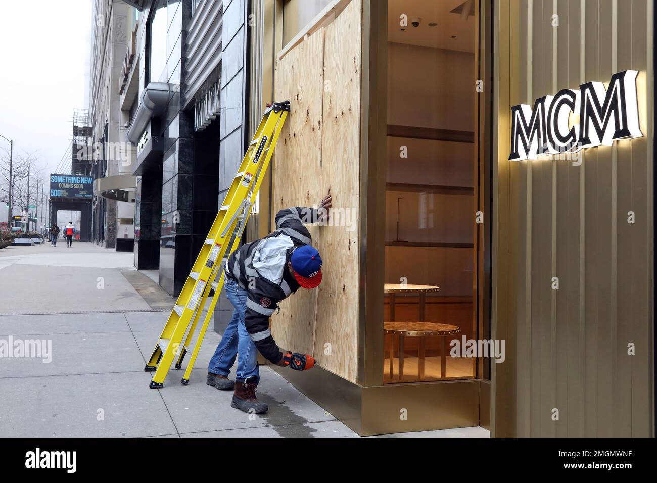 CORRECTS SPELLING OF FIRST NAME TO DEMETRICS NOT DEMETRIUS DemetricsSims boards up an MCM boutique along Michigan Ave. Thursday March 19 2020 in Chicago. Sims says the owner of MCM a