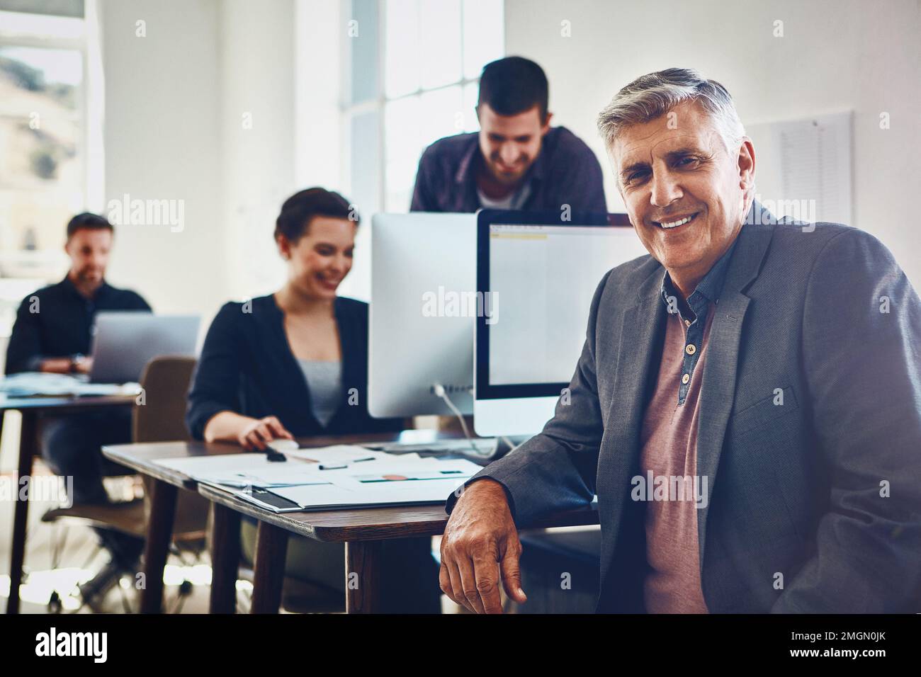 Senior, portrait and business man in office or company workplace. Leadership, ceo and happy elderly male employee working on marketing report Stock Photo