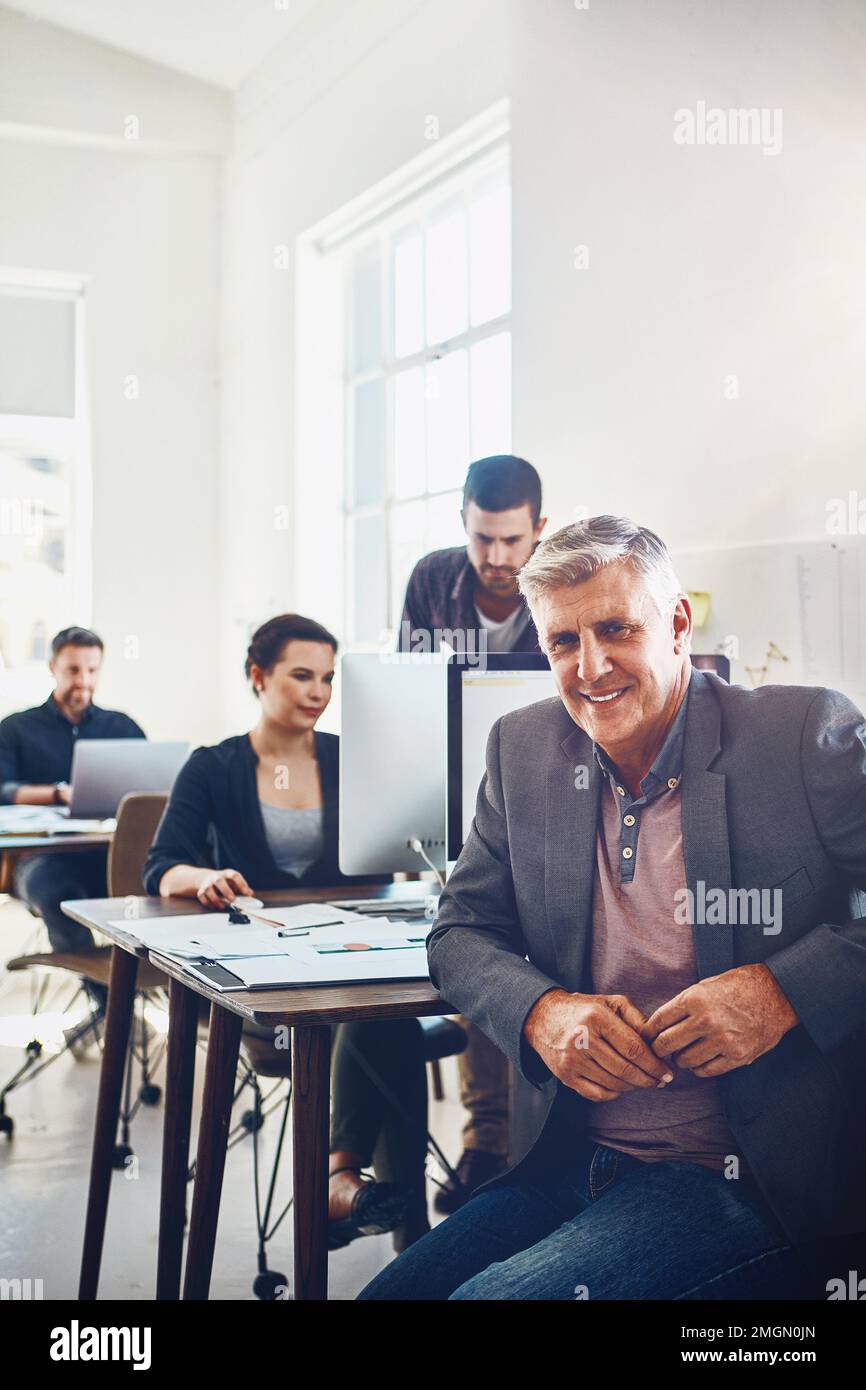 Business, senior and portrait of man in office or company workplace. Leadership, ceo or happy elderly male employee or manager with coworkers working Stock Photo