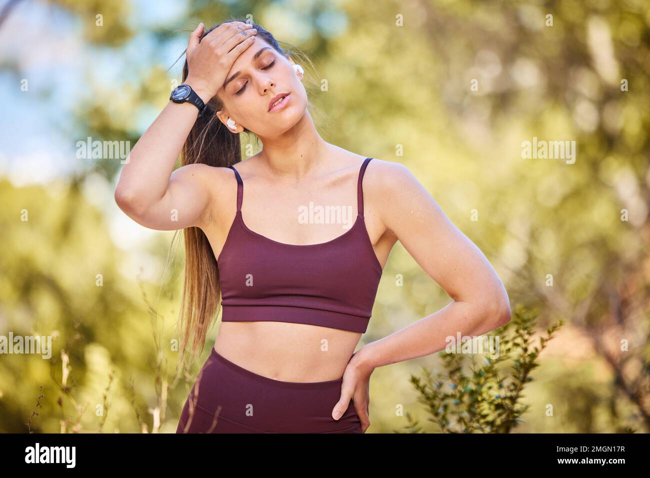 Tired, running and sweat with woman at nature park for workout, cardio or endurance training. Exhausted, breathing and fatigue with girl runner Stock Photo