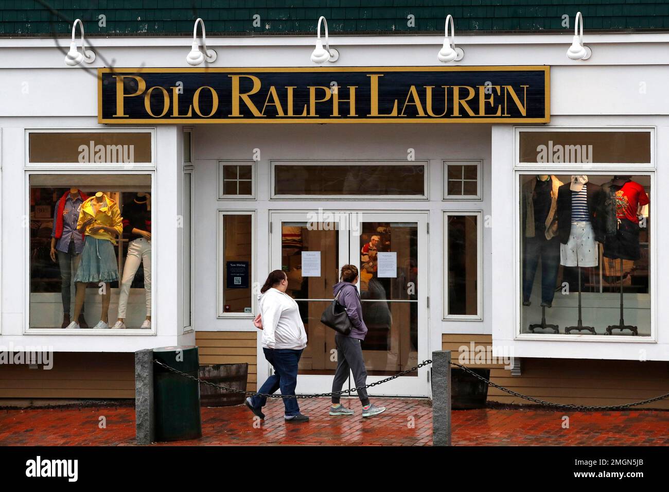 Women read a notice announcing the temporary closure of a Polo Ralph Lauren  store, Tuesday, March 17, 2020, in Freeport, Maine. Most of the retail  stores in town including the L.L. Bean