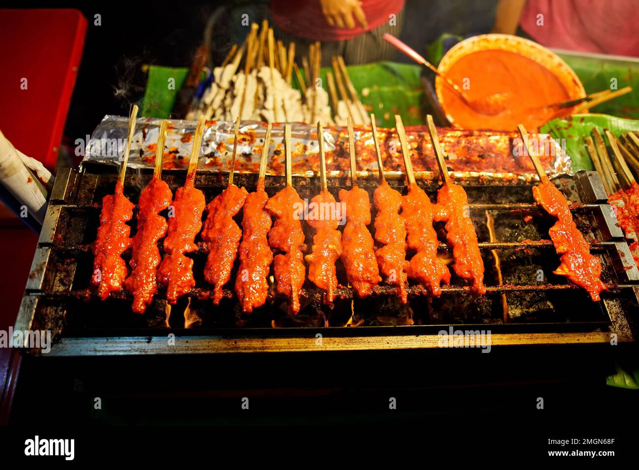 Street food of Thai meatball fried with spicy sauce at barbecue without hand at outdoor night market at the Chinese New year in Bangkok Chinatown in T Stock Photo