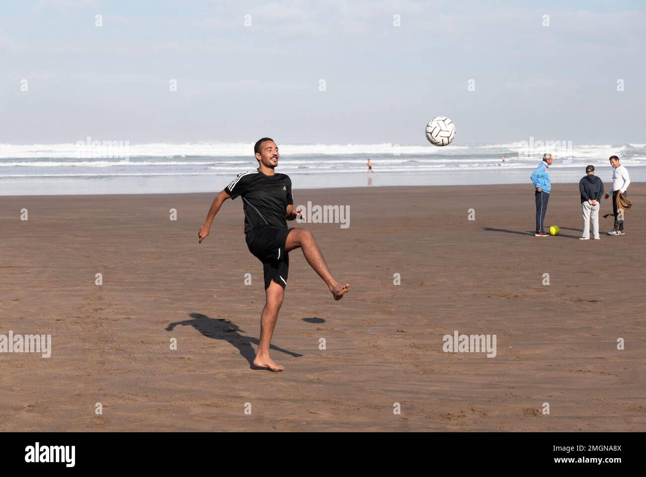 Football is big in Morocco, they got to World Cup semis, and everywhere they play, here on the beach at Casablanca for a break from work Stock Photo