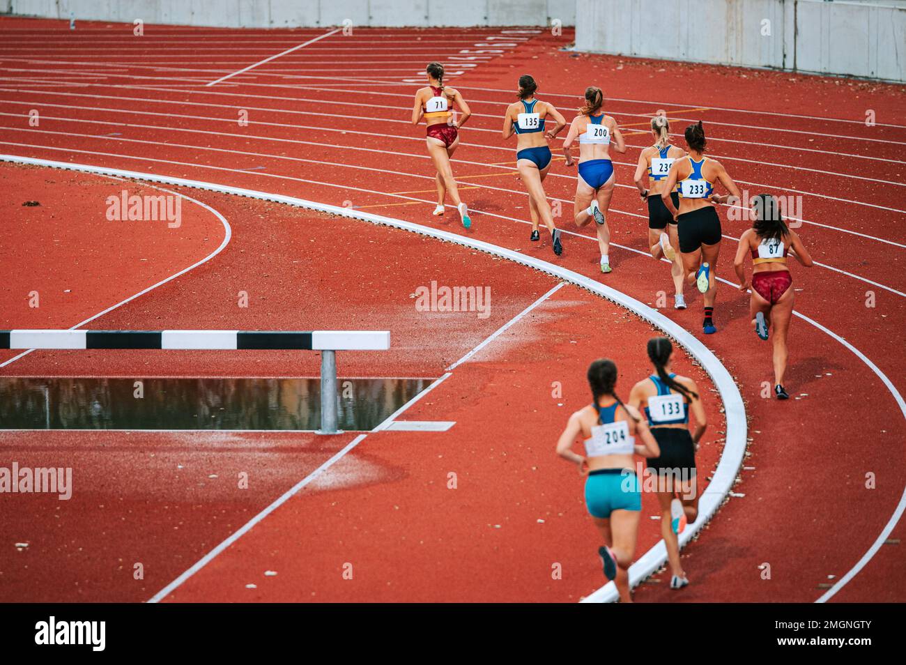 Female athletes pushing their limits in long distance race. Perfect for