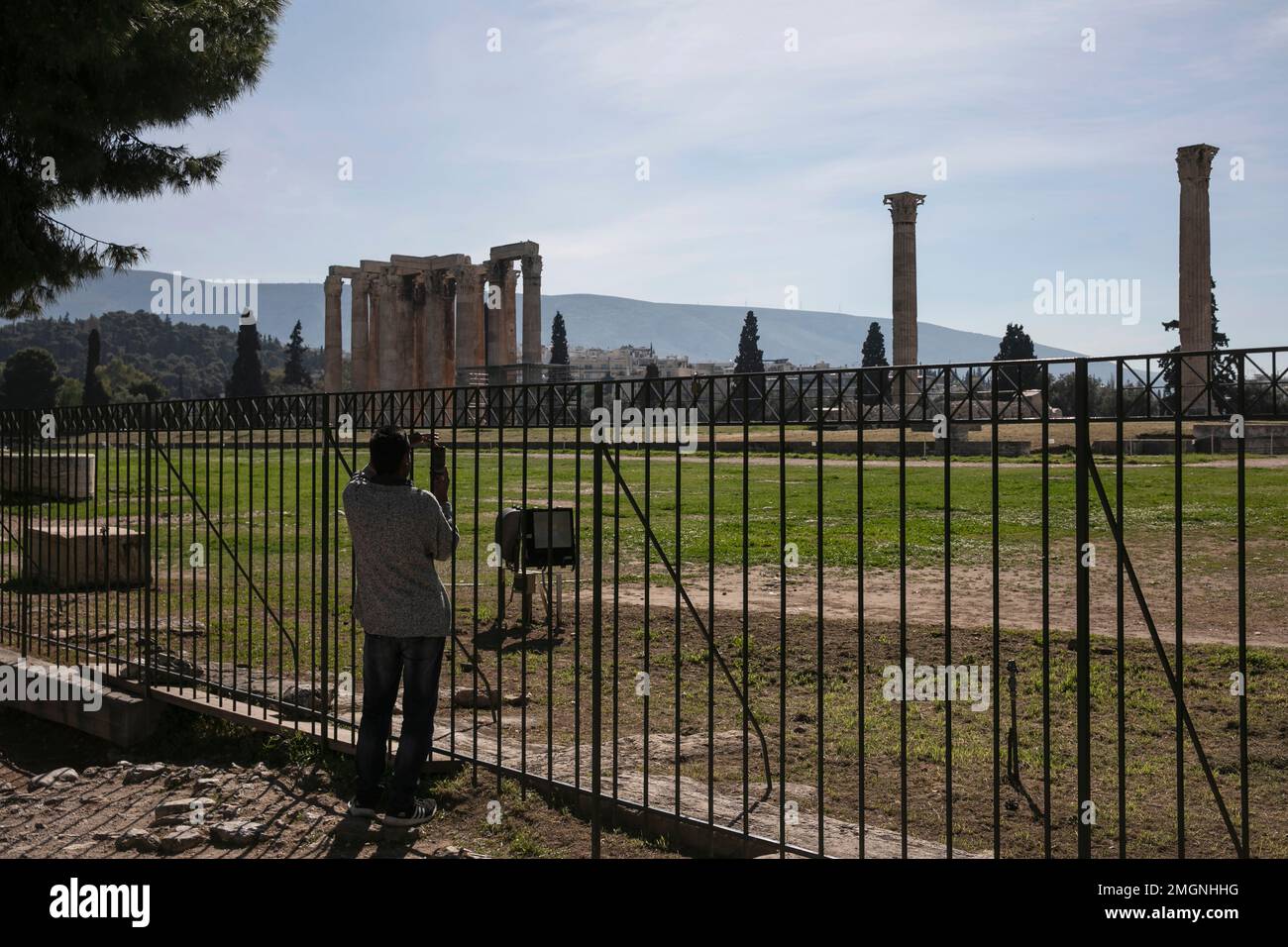Zues Railing A tourist takes photographs from behind railings at the archaeological ...