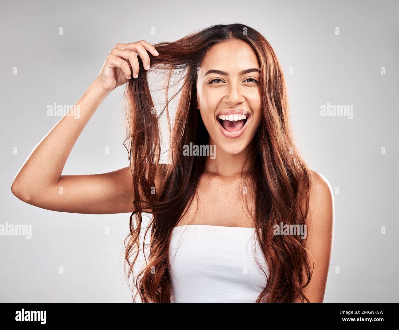 Hair, portrait and face of excited woman for skin care, makeup and cosmetics with smile in studio. Headshot of aesthetic model person happy about Stock Photo
