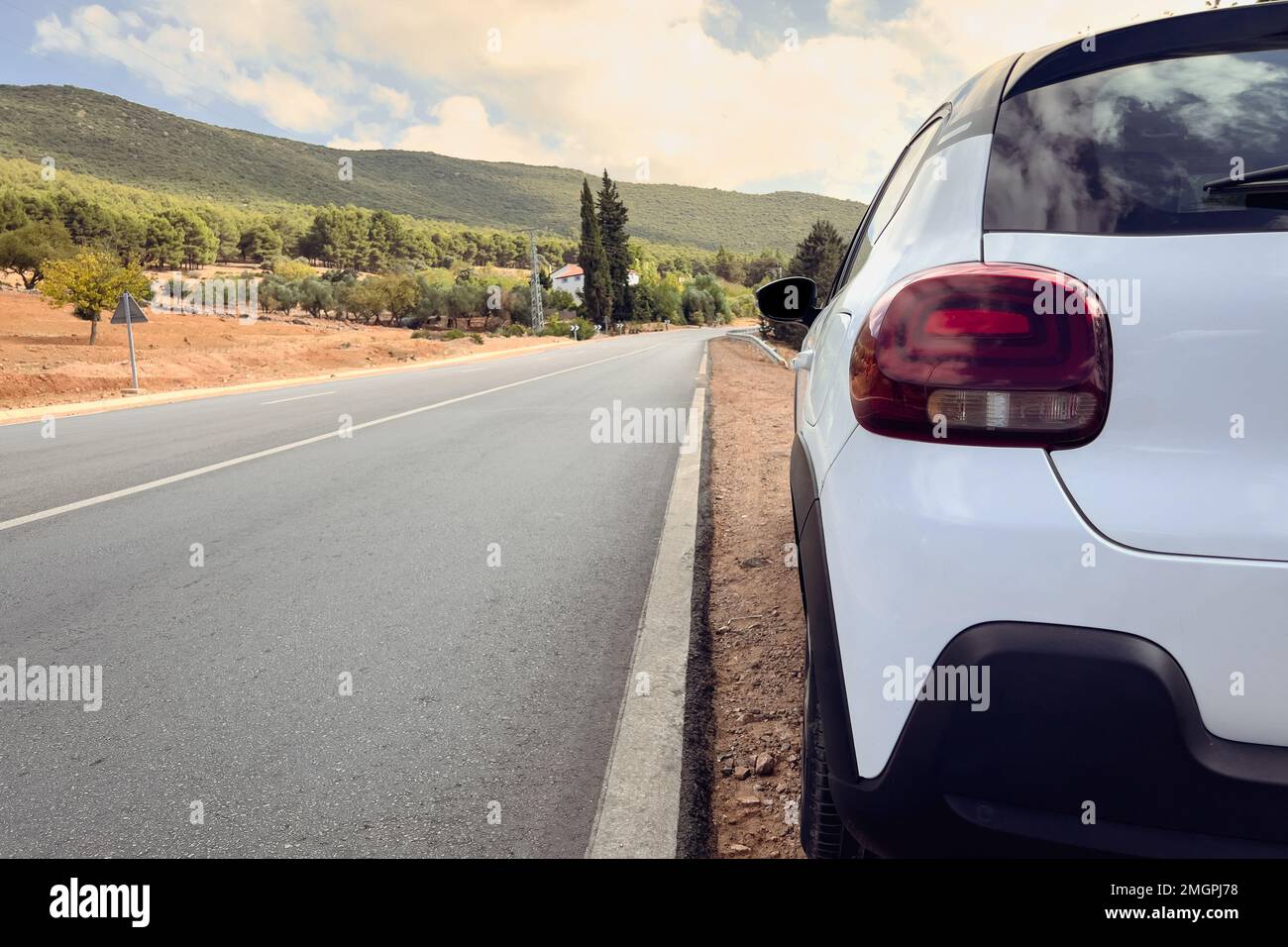 white hatchback car parked on the roadside Stock Photo Alamy