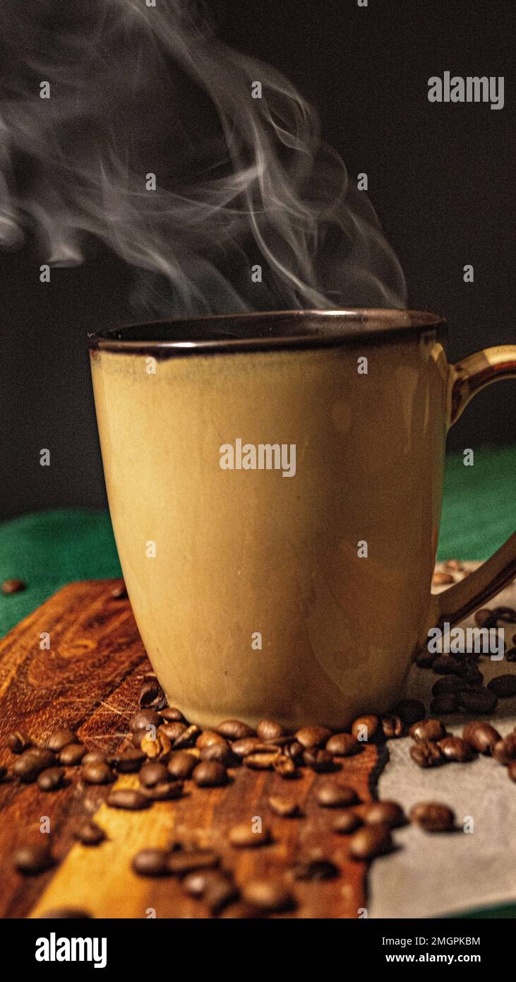 A vertical closeup shot of a filled coffee mug with steam coming out of it Stock Photo
