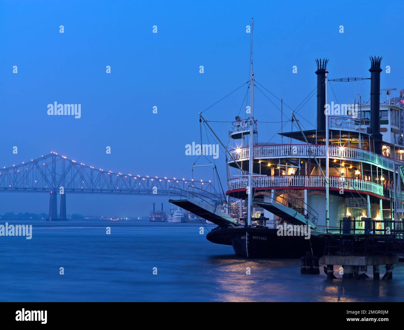 USA,Louisiana,New Orleans, Paddle boat and The Crescent City Connection bridge spans over the Mississippi River, connecting downtown New Orleans. Stock Photo